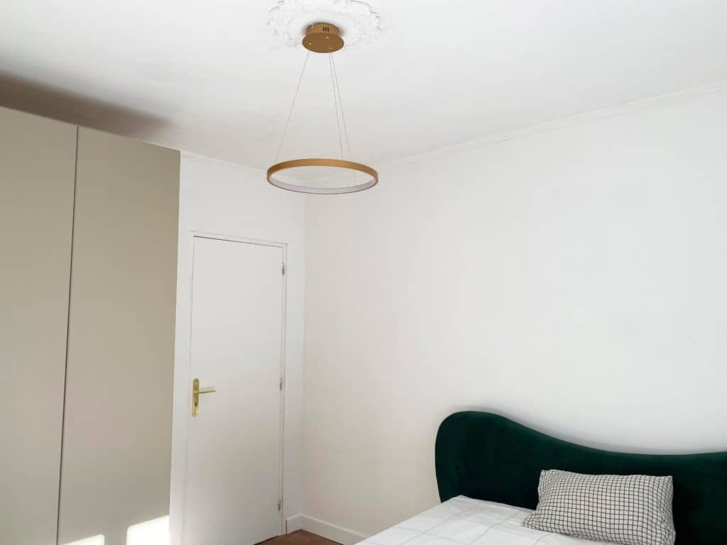 Chambre adulte cadre de lit velours vert murs blancs suspension dorée