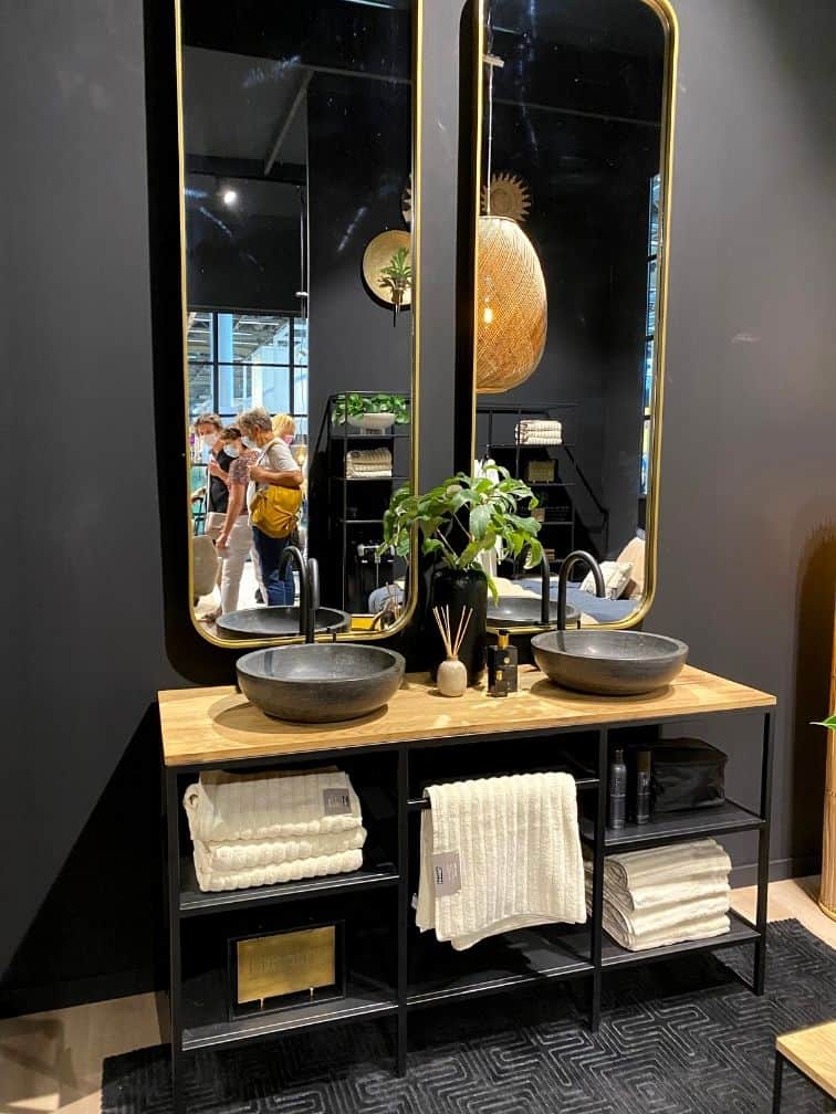 Salle de bain murs noirs double vasque béton robinet noir miroir doré allongé