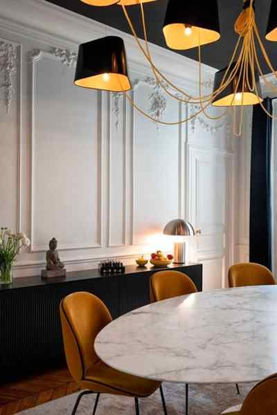 Salle à manger table marbre fauteuils velours plafond noir moulures blanches
