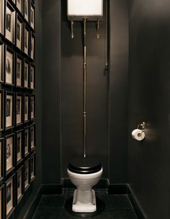 Toilettes noirs avec mur de cadres et chasse d'eau au plafond