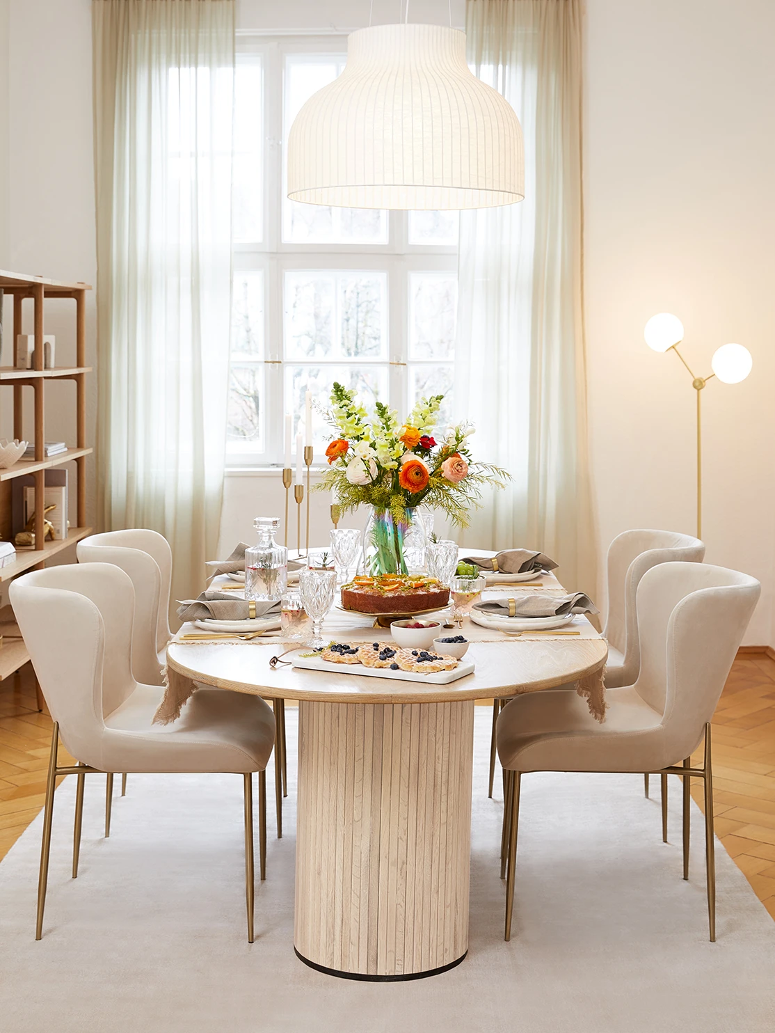 Salle à manger parisienne avec table ovale pieds ronds et chaises velours