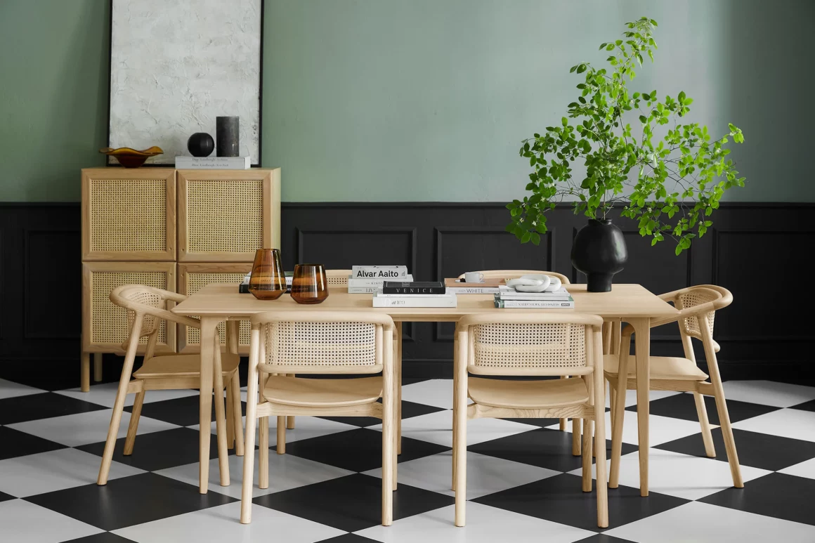 Salle à manger style rustique chic avec moulures murales noires, bois et rotin