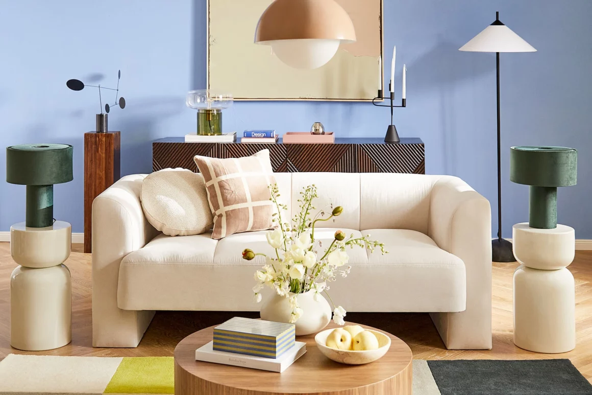 Salon mur coloré canapé blanc confortable tapis bois ronde