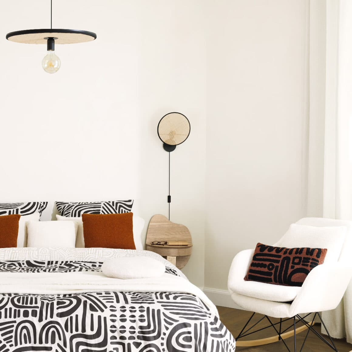 Suspension en rotin noire tressée au design bohème chic, avec ampoule apparente, idéale pour éclairer et décorer une salle à manger moderne et conviviale